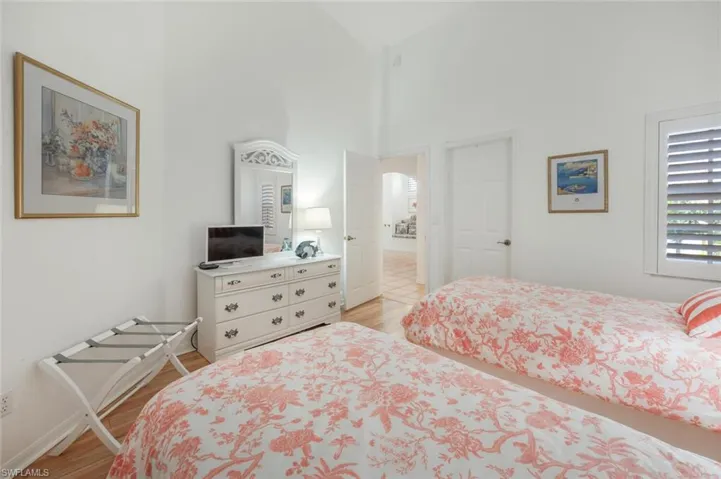 Bedroom with high vaulted ceiling and light Wood finished floors