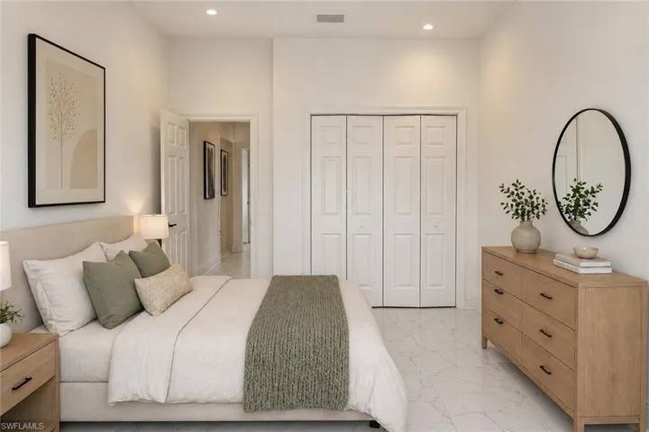 Spacious room featuring white walls, recessed lighting, and large bi-fold closet doors. Image digitally enhanced and virtually altered; actual property condition may differ.