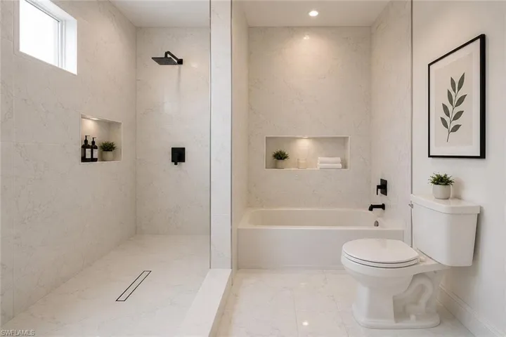 Contemporary bathroom featuring full-height marble-look tile, a frameless glass shower enclosure, a recessed shower niche with integrated lighting, a rain shower head, and a bathtub with matte black fixtures