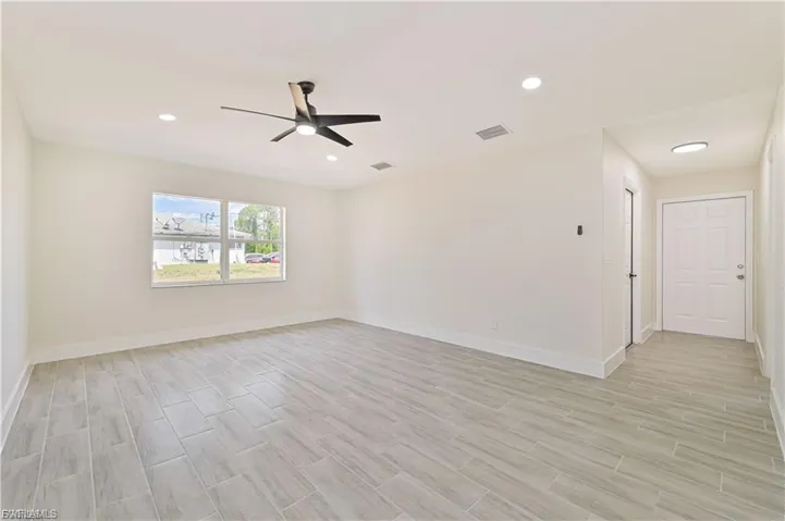Unfurnished room featuring wood finish floors, ceiling fan, and recessed lighting