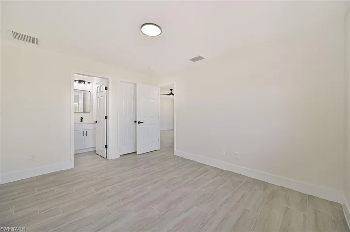 Unfurnished bedroom with wood tiled floors and ensuite bath