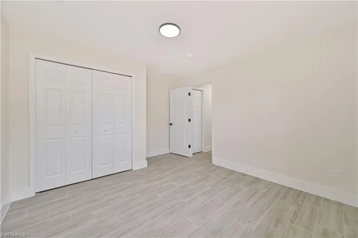 Unfurnished bedroom with a closet and wood tiled floors