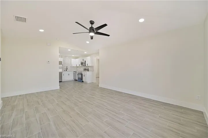 Unfurnished living room featuring ceiling fan, wood tiled floors, and recessed lighting