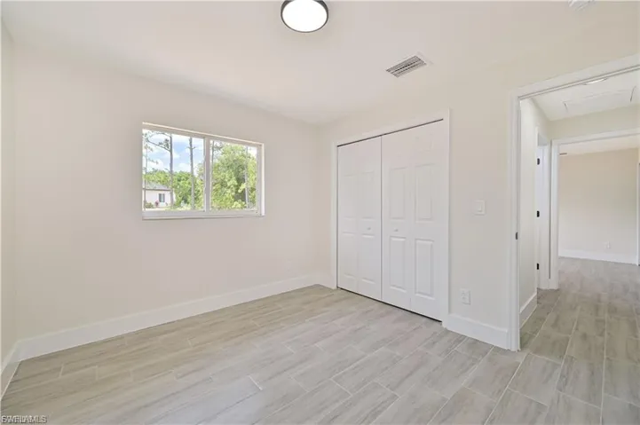 Unfurnished bedroom with a closet and wood tiled floors