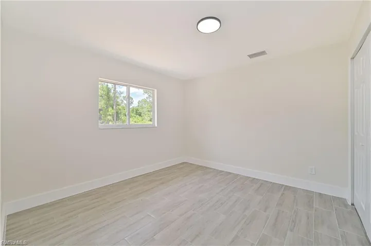 Unfurnished bedroom featuring a closet and wood finish floors