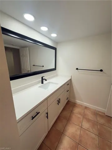 Bathroom with vanity, light tile patterned floors, and recessed lighting