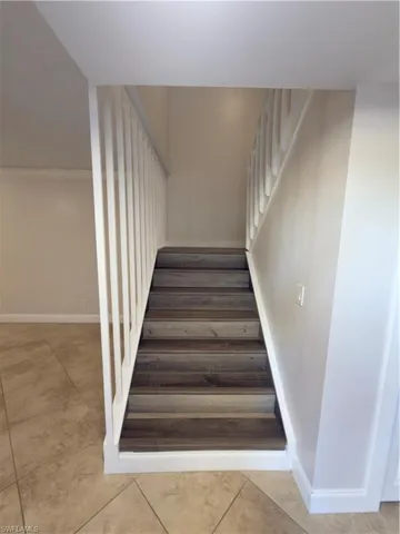 Stairs featuring ornamental molding and tile patterned floors