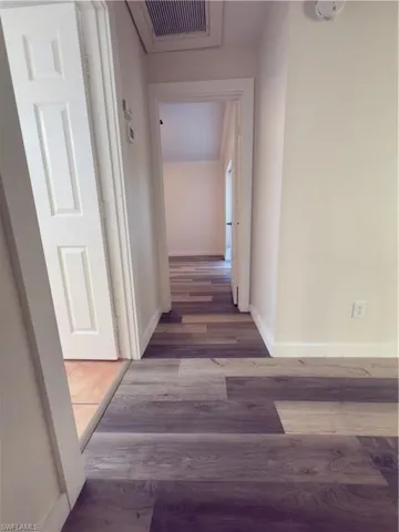 Hallway with wood finished floors and baseboards