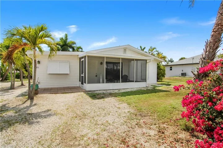 Front of property featuring a screened porch and a lawn