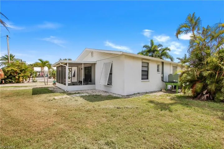 Front view of house with a screened porch and a lawn