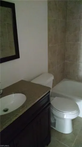Full bath with vanity and tile patterned flooring