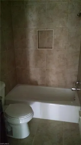 Bathroom featuring tile patterned floors,  shower combination, and vanity