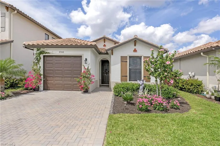 Mediterranean / spanish-style home with a garage and a front yard