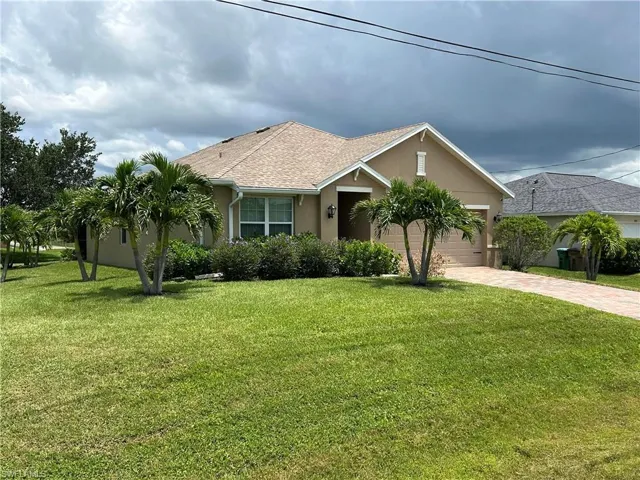 Single story home with stucco siding, decorative driveway, a front yard, roof with shingles, and a garage