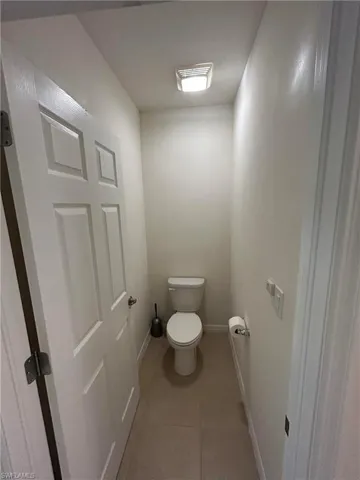 Bathroom featuring light tile patterned floors and toilet
