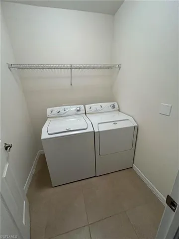 Laundry room with tile patterned flooring and washer and dryer