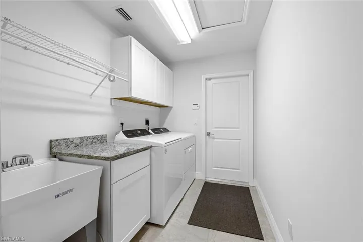 This oversized laundry room has a brand new washer and dryer, as well as a utility sink. It is conveniently located just off the garage.