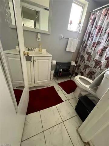Bathroom with a shower with shower curtain, vanity, and toilet
