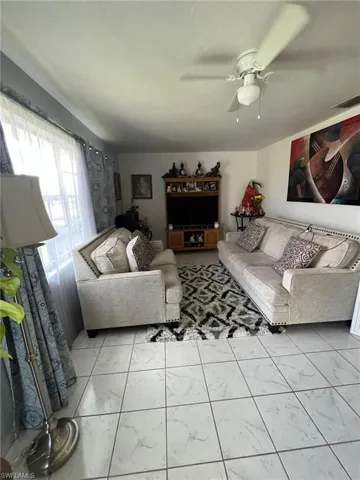Living room featuring ceiling fan and a textured ceiling