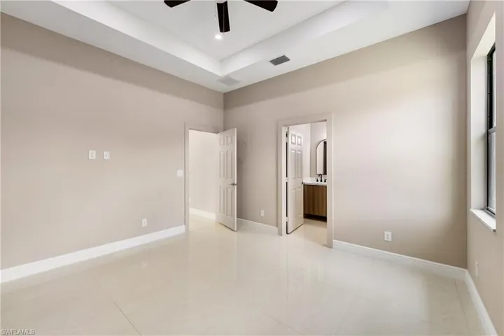 Unfurnished room featuring a raised ceiling and ceiling fan