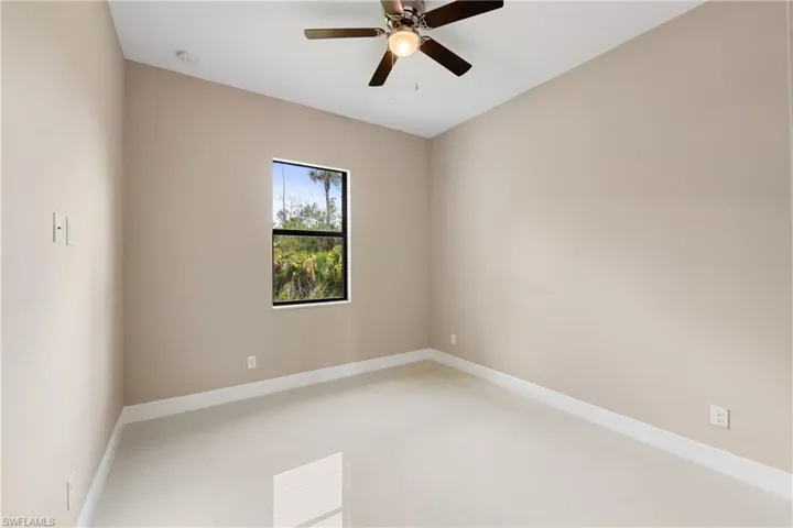 Empty room with ceiling fan and baseboards