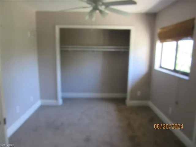 Unfurnished bedroom with carpet flooring, a closet, and ceiling fan