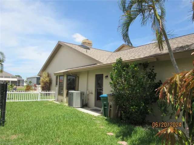 Rear view of property featuring central air condition unit and a yard