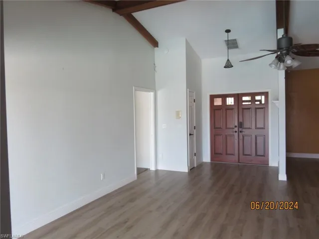 Entrance foyer featuring beamed ceiling, hardwood / wood-style flooring, and high vaulted ceiling