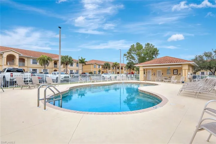 Community pool with a patio area and a residential view