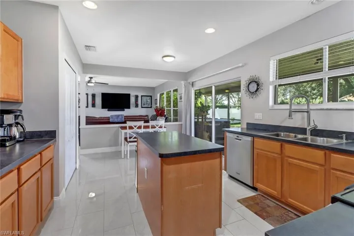 Kitchen with a center island, stainless steel dishwasher, sink, and plenty of natural light