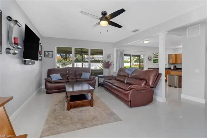Family room featuring decorative columns and ceiling fan