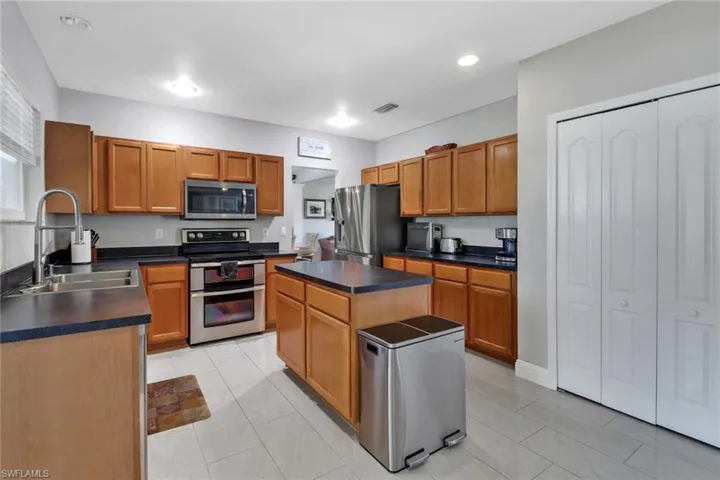 Kitchen with a center island, appliances with stainless steel finishes, sink, and light tile patterned floors