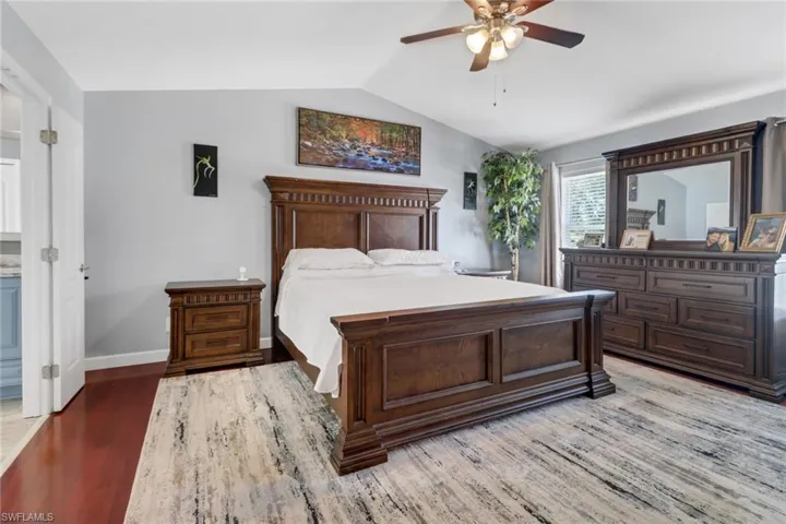 Bedroom with lofted ceiling, wood-type flooring, and ceiling fan