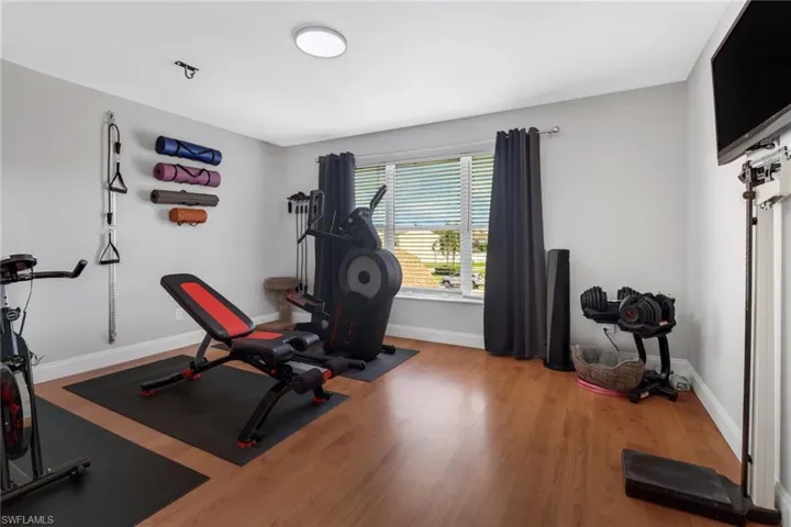 Guest bedroom with hardwood floors currently utilized as a home gym