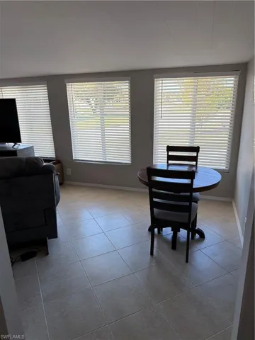 The interior features tile flooring and multiple windows with blinds, providing natural light