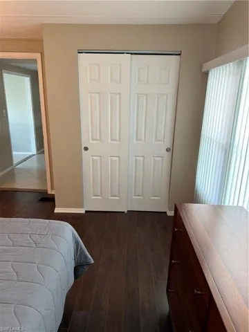 The property features dark wood-look flooring throughout, complemented by light-colored walls and white trim