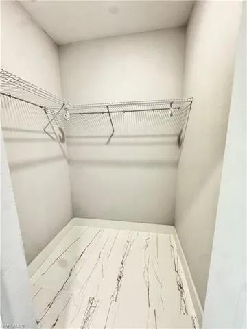 Walk in closet featuring marble finish floors