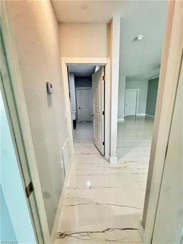 Corridor featuring light marble finish flooring