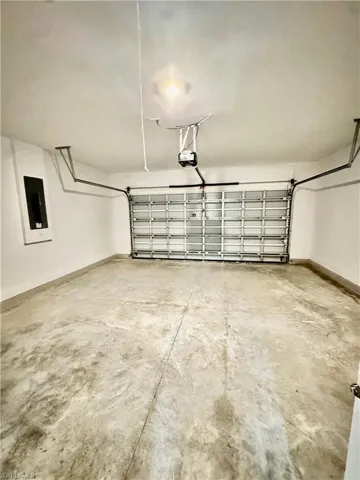 Garage with electric panel and a garage door opener