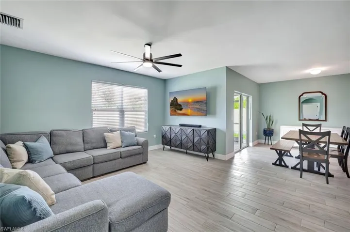 Living area with a ceiling fan and light wood-style floors
