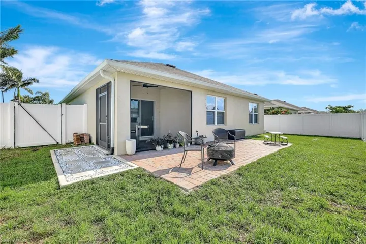 Rear view of property with a gate, a fire pit, stucco siding, a patio, and a fenced backyard