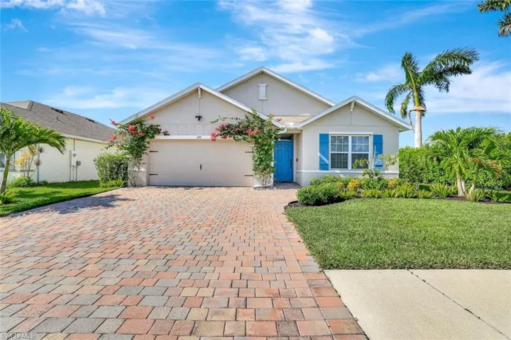 Ranch-style home featuring stucco siding, a garage, decorative driveway, and a front lawn