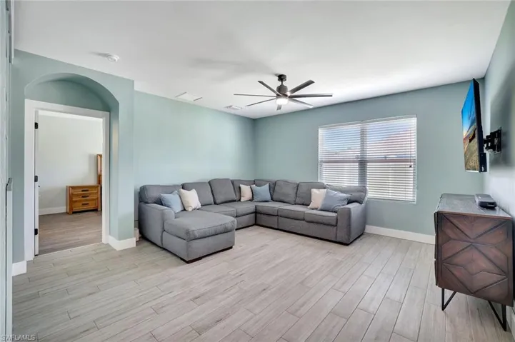Living area featuring light wood-style floors and a ceiling fan