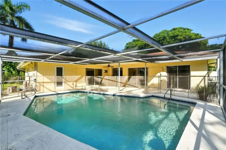 Outdoor pool with a sunroom, a patio area, and a lanai