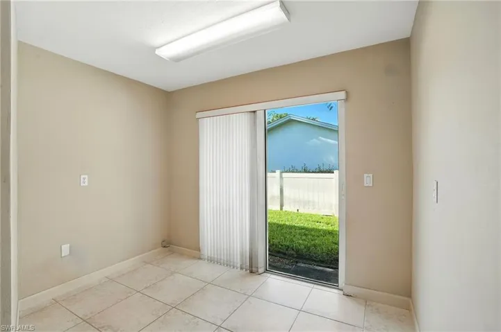 Doorway to outside featuring baseboards and tile patterned flooring