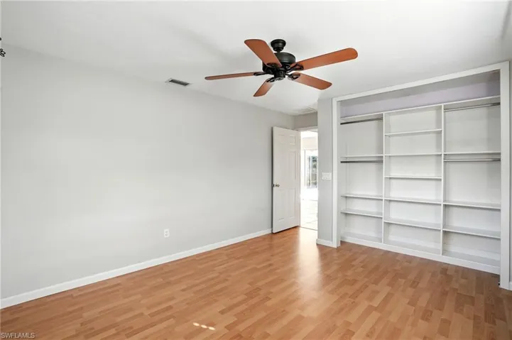 Unfurnished bedroom featuring light wood-type flooring, a closet, and a ceiling fan
