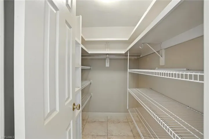 Walk in closet with light tile patterned flooring
