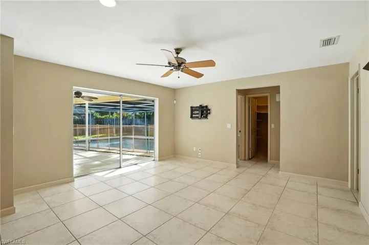 Unfurnished room featuring a sunroom, light tile patterned floors, and a ceiling fan