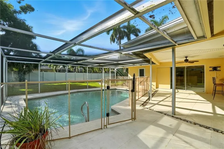 View of pool with a patio area, glass enclosure, a sunroom, and ceiling fan