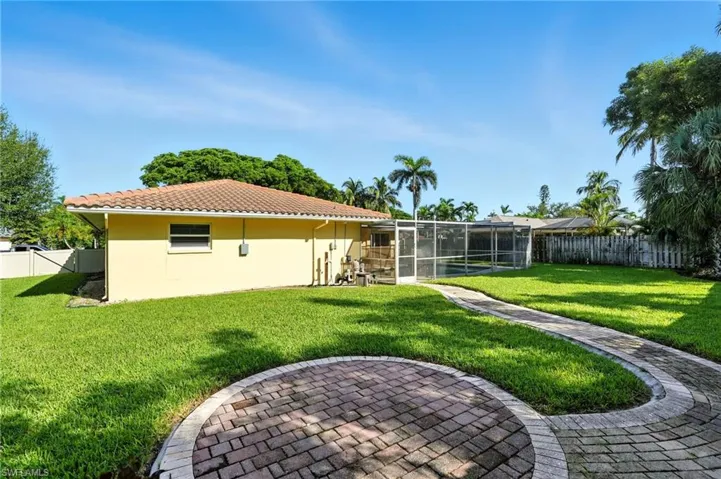 Fenced backyard with a sunroom and a lanai